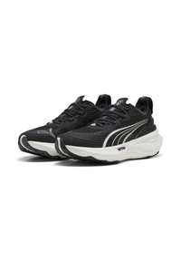 Chaussures de sport noires avec une tige texturée, des accents blancs, un bout arrondi et une semelle épaisse et rembourrée avec un motif de traction noir.