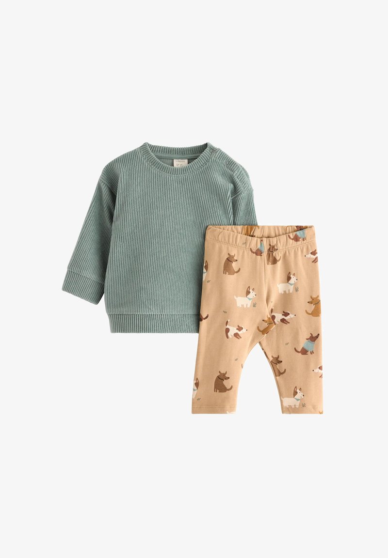 Grøn, ribbet langærmet bluse parret med beige leggings med hundemønster. Blødt stof med elastisk talje for komfort.