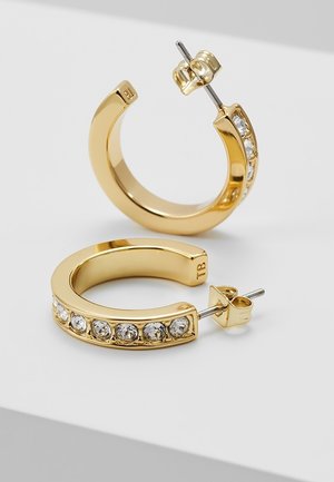 Gouden halve-hoep oorbellen met zes ingebedde heldere edelstenen in elk, voorzien van stekers en subtiele "TB" gravure aan de binnenkant.