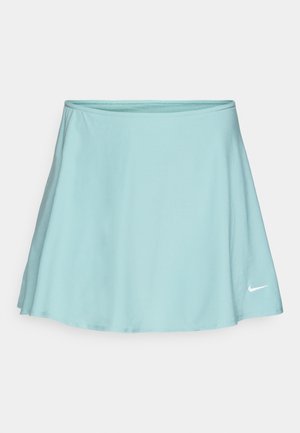 Light blue athletic skirt with a flared design, made of soft fabric. Features a white Nike logo at the lower right hem.
