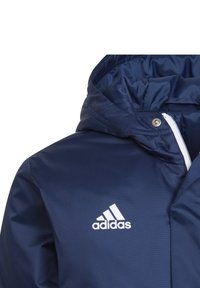Marineblaue Windbreaker-Jacke mit Kapuze, aus glattem Material; verfügt über einen weißen Reißverschluss und das Adidas-Logo auf der Brust.