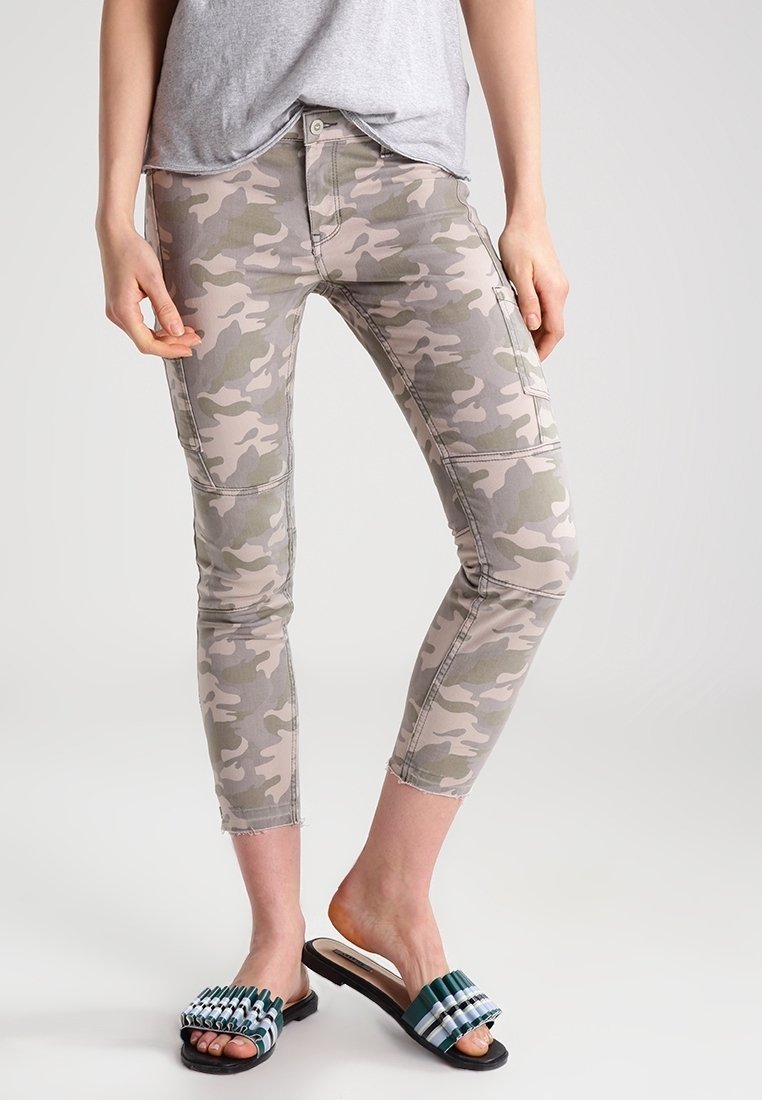 Kamikaze-mönstrade skinny jeans i dämpade beige och gröna toner, med låg midja och cropped längd. Kombineras med stiliga sandaler.