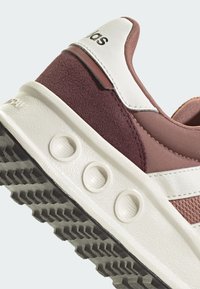 Bordové a růžové sportovní boty s texturovaným nubukem a síťovinou, bílými koženými akcenty a gumovou podrážkou s výraznými vzory.