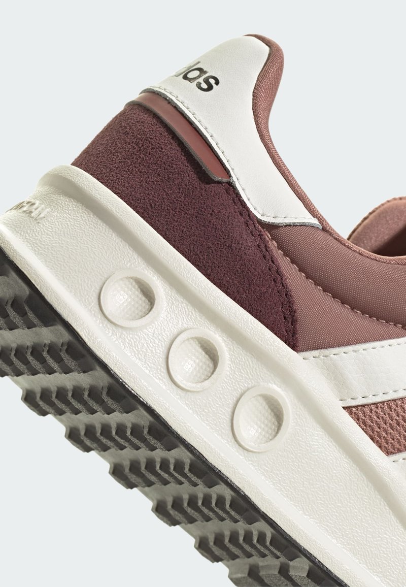 Bordeauxfarbene und rosa Sport Schuhe mit einem strukturierten Wildleder- und Mesh-Obermaterial, weißen Lederakzenten und einer Gummisohle mit auffälligen Mustern.