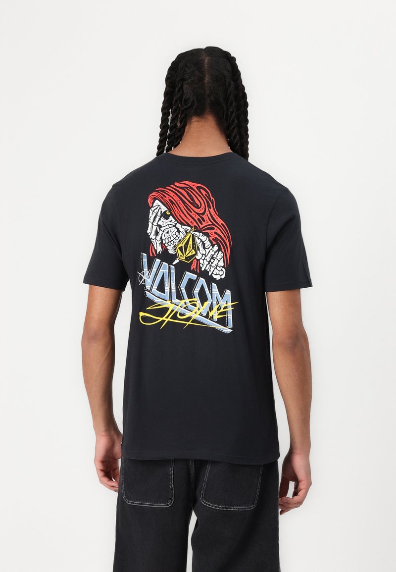 Black short-sleeve t-shirt featuring a colorful graphic of a stylized face and the "Volcom" logo on the back. Soft cotton material.