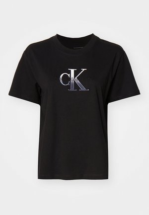 Mustmust värvi puuvillane T-särk ümmarguse kaelusega. Ees on hõbedane tikandiga "cK" logo ja logo all on tekst "Calvin Klein Jeans". Lühikesed varrukad.