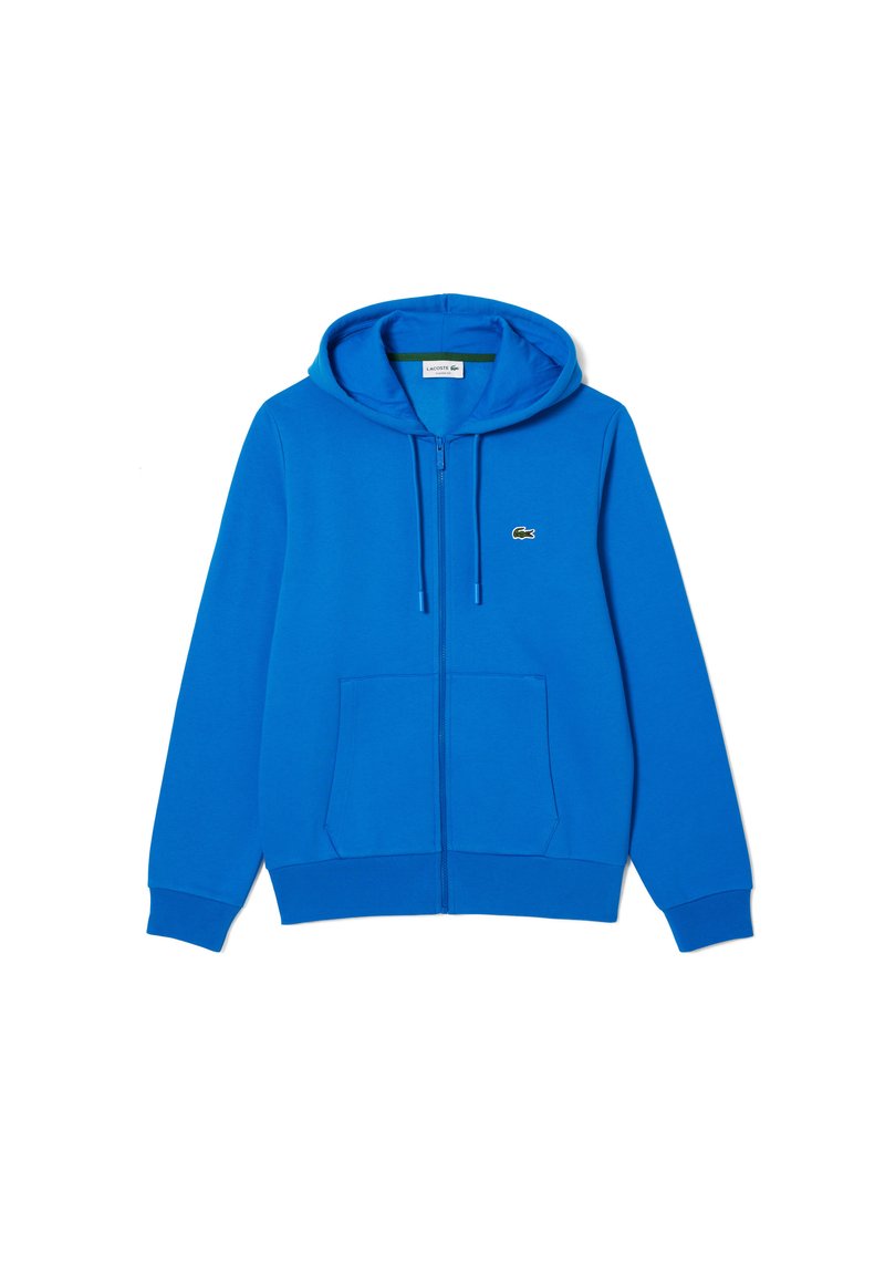 Sudadera con cremallera azul hecha de una mezcla de algodón. Cuenta con capucha ajustable, bolsillos frontales y un pequeño logo de Lacoste en el lado izquierdo del pecho.