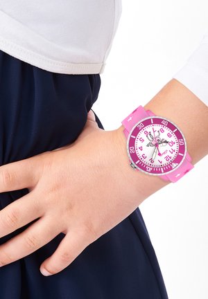 Pink rubber watch with a round white face, oversized numbers, and a ballet dancer design. Features pink and purple accents, secured on a wrist.