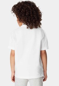 Vit kortärmad t-shirt med baksida av kragen och avslappnad passform. Tyget verkar glatt, med en enfärgad yta och inga synliga mönster.