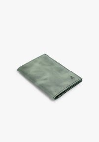 Cartera de cuero verde con textura suave, forma rectangular y bordes cosidos. Presenta un logotipo grabado en la esquina inferior derecha.