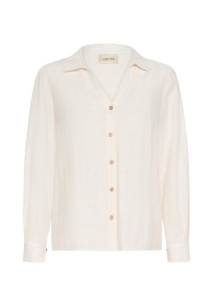 Chemise ivoire à manches longues en tissu texturé, avec un décolleté en V, une fermeture à boutons et une coupe décontractée avec des poignets. Étiquette de marque "CREAM" visible.