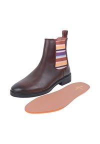 Brązowe skórzane botki za kostkę z wielokolorowymi paskami elastycznymi po bokach, płaską gumową podeszwą oraz wyjmowaną beżową wkładką z pomarańczową krawędzią.