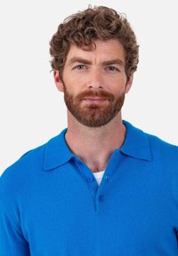 Hellblaues Poloshirt mit klassischem Kragen und drei Knöpfen. Weiche Textur, kurze Ärmel und lockere Passform. Sauberes, schlichtes Design.