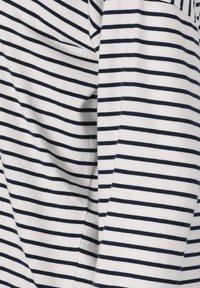 Gestreepte longsleeve shirt in wit en marineblauw. Zachte stof met horizontale strepen, voorzien van een relaxte pasvorm en subtiele textuur.