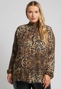 Blusa con stampa animalier in una miscela di marroni e beige, con collo alto, maniche lunghe e dettagli arricciati sullo scollo.