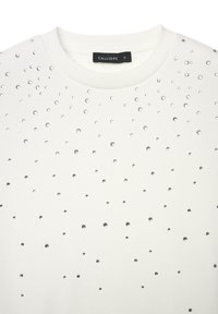 Maglione bianco con scollo rotondo e maniche corte, decorato con piccoli strass argentati sparsi su tutta la parte anteriore, realizzato in un tessuto morbido.