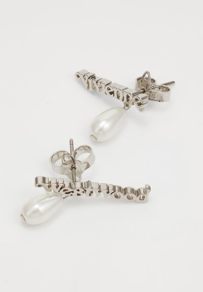 Boucles d'oreilles en argent présentant un design de texte ondulé avec « Westwood » et une perle blanche en goutte à l'extrémité. Texture métallique avec finition brillante.