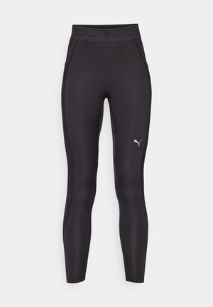 Leggings deportivos negros con una cinturilla ancha. Presentan un panel lateral texturizado y un pequeño logo plateado de Puma en la parte inferior de la pierna.