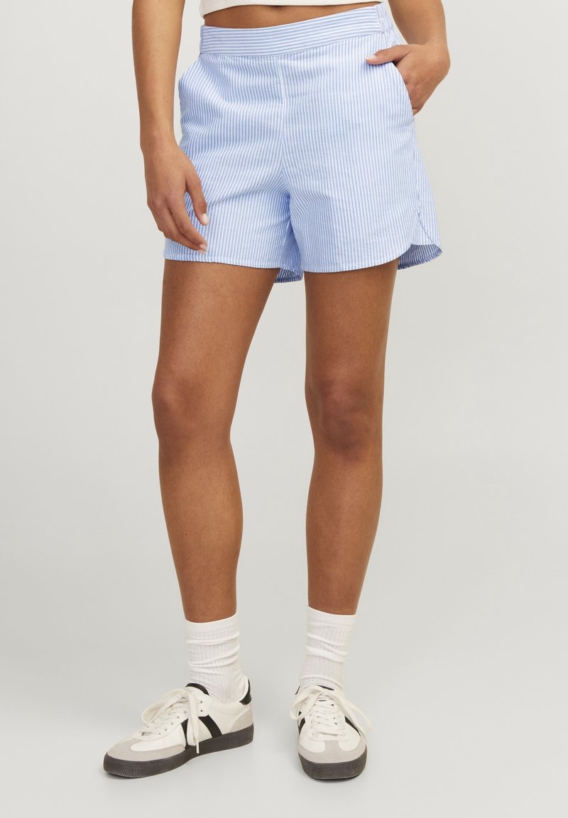 Blå och vita randiga shorts med ett mjukt tyg, elastisk midja och sidofickor, kombinerat med vita sneakers och strumpor.