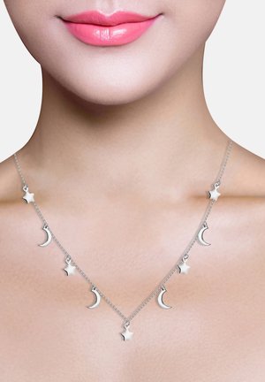 Sølv halskæde med skiftende halvmåne- og stjernecharms på en delikat kæde, der viser en poleret overflade og minimalistisk design.