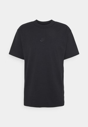 Czarna koszulka Nike z krótkim rękawem, okrągłym dekoltem oraz małym, czarnym, haftowanym logo Nike na środku klatki piersiowej.