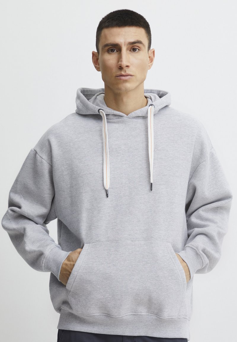 Gray hooded sweatshirt with a front pocket, drawstrings, and ribbed cuffs. Soft texture with a relaxed, oversized fit.