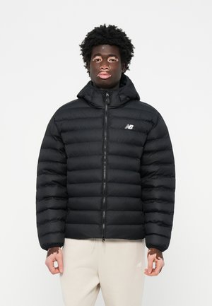 Sort puffa-jakke med lynlås foran, hætte og kviltet design. Har et lille hvidt logo på venstre bryst og elastiske manchetter.