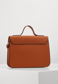 Sac à main en cuir marron avec une forme rectangulaire élégante, une poignée sur le dessus et des finitions noires, doté d'une fermeture à rabat magnétique.