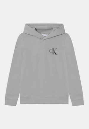 Felpa grigia chiara con cappuccio, maniche lunghe e piccolo logo nero "CK Calvin Klein Jeans" sul lato sinistro del petto.