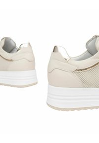 Sneakers beige con tomaia in rete testurizzata, accenti metallici e suola piatta bianca. Presentano una punta arrotondata e un colletto imbottito.