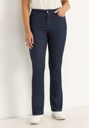 Donkerblauwe denim jeans met een rechte pijpdesing, voorzien van een knoopsluiting, vijf zakken en een gladde textuur. G gedragen met witte sneakers.