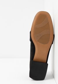 Chaussure en daim noire avec un bout carré et une semelle en caoutchouc, dotée d'une semelle intérieure marron clair et d'une adhérence texturée. Taille indiquée : 37.