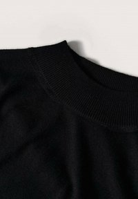 Black sweater fabric with a ribbed, crew neck. The texture is soft and smooth, showcasing a classic design without additional details.