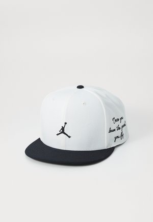 White cap with a black visor and embroidered Jumpman logo; features text on the side, crafted from fabric with a structured fit.