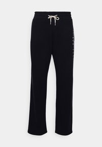 Pantalones de chándal negros con cintura ajustable, hechos de un tejido suave. Presenta un diseño de pierna recta y una impresión gráfica a lo largo del costado.