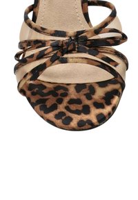 Sandalia de tacón alto con estampado de leopardo y correas cruzadas, que cuenta con una suave suela beige y una punta redondeada.