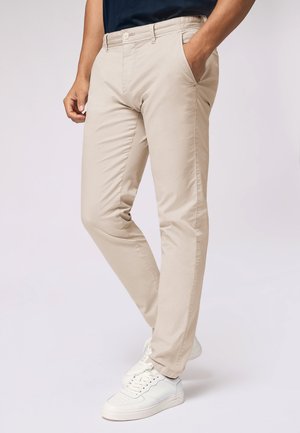Beige slim-fit chinos with a flat front, side pockets, and back pockets. Made from cotton, featuring a smooth texture and minimal detailing.
