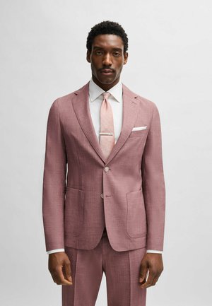 Light pink men's suit with a textured finish, single-breasted jacket, two front pockets, and matching tie. White dress shirt underneath.