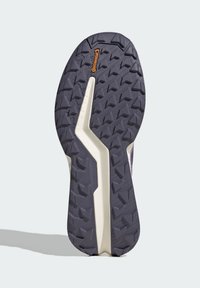 Lívancová podrážka sportovní obuvi s fialovými vlákny, s robustním trojúhelníkovým protiskluzovým vzorem a logem Continental blízko horního středu.