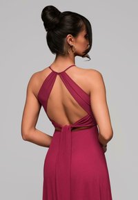 Abito halter color malva con profondo scollo aperto sulla schiena, spalline drappeggiate e dettaglio in vita legato, realizzato in un tessuto morbido e fluente con una texture liscia.