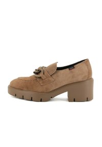 Scarpa in suede marrone con punta arrotondata, tomaia testurizzata, cintura decorativa con un accento circolare e tacco spesso solido marrone.