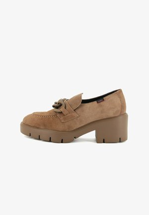 Chaussure en suede marron avec un bout arrondi, un dessus texturé, une sangle décorative avec un accent circulaire, et un talon épais de couleur marron uni.