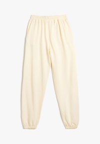 Pantalones de chándal color crema con cintura y puños elásticos. Fabricados con tela suave, cuentan con dos bolsillos laterales y un corte relajado.