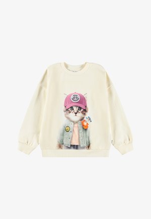 Kremowy sweter z dużą grafiką przedstawiającą kota w różowej czapce i jasnoszarym kardiganie, ozdobionym kwiatem i uśmiechniętą naszywką.