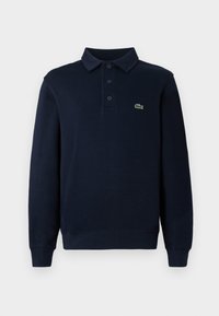 Navyblaues Langarm-Polohemd mit Knopfleiste und kleinem grünen Krokodil-Logo auf der Brust.