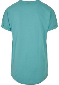 Camiseta de manga corta color turquesa con escote redondo y puños enrollados, hecha de un material suave y ligero. Textura suave, corte casual.
