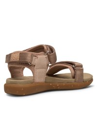 Bruna sandaler med justerbara tygremmar, vadderad fotbädd och en texturerad gummisula. Har öppen baksida och stöd för vristen.