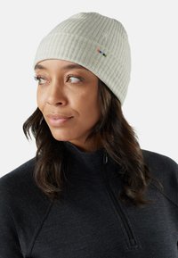 Gorro de punto acanalado gris claro con un ligero estiramiento. Presenta un pequeño logotipo y rayas multicolores en el costado. Textura suave.