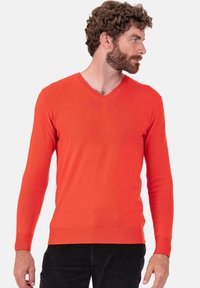 Pull à col en V, manches longues, tricoté en orange vif, avec poignets et ourlet côtelés. Le matériau semble doux avec une texture lisse.