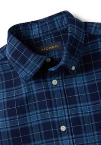 Navy blue plaid shirt with a button-down collar, featuring light blue and white check patterns, made from a soft textile. Label reads "PIOMBO."